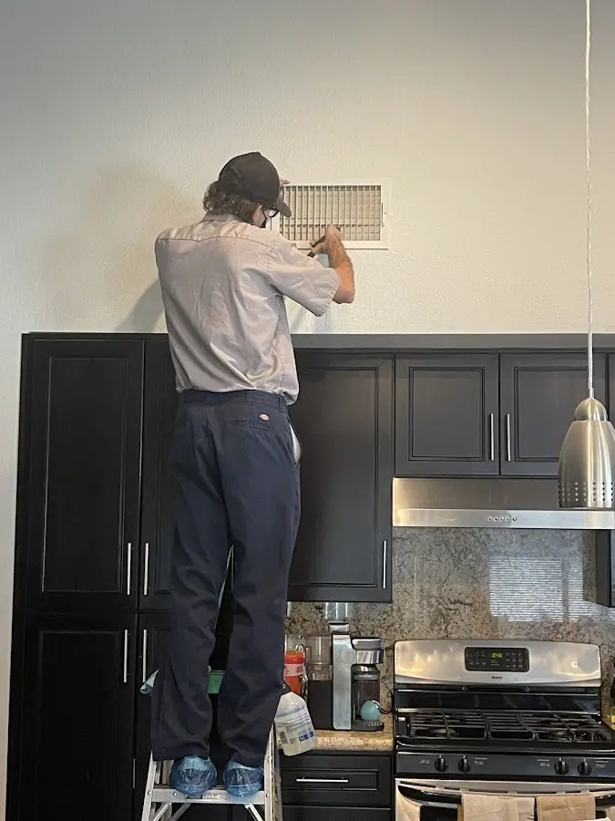 Technician inspecting an air vent during HVAC service in Texarkana